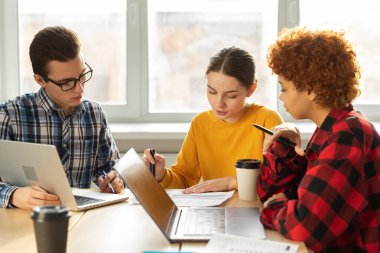 Takım çalışması beyin fırtınası. Çeşitli meslektaşlar birlikte çalışarak mali istatistikleri tartışırlar. Bir grup mutlu modern insan yaratıcı ofiste oturmuş iş tartışıyorlar. Genç profesyonel takım