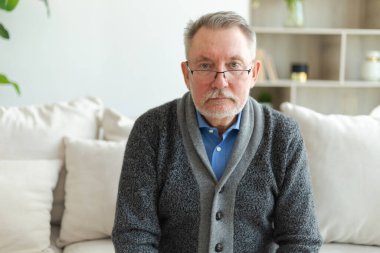 Evde kendine güveni tam orta yaşlı bir adam var. Yaşlı olgun 70 'lerin erkeği gülümsüyor. Mutlu, yaşlı ve sakallı büyükbaba kameraya bakıyor. Yüz portresi. Mutlu insanlar.