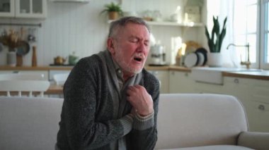 Kalp krizi, kalp krizi. Memnuniyetsiz orta yaşlı adam göğüs ağrısı çekiyor kalp krizi geçiriyor evde sağlık sorunları var. Yaşlı büyükbaba göğsüne dokunuyor ve damar tıkanıklığı yaşıyor.