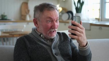 Arkadaşlarıyla video görüşmesinde orta yaşlı adam sohbetin kutlu olsun. Yaşlı, olgun büyükbabaya gülüp yetişkin çocuklarla internette konuşarak eğleniyor. Eski nesil modern teknoloji kullanımı