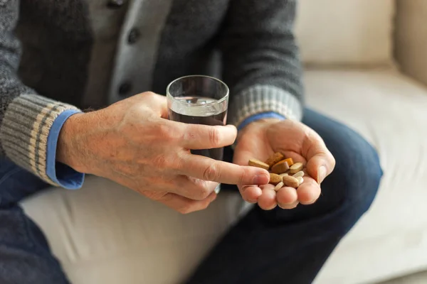 Hands with pills. Senior man hands holding medical pill and glass of water. Mature old senior grandfather taking medication cure pills vitamin. Age prescription medicine healthcare therapy concept