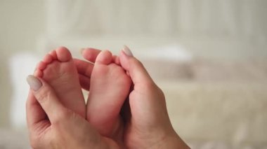 Mutlu bir aile. Anne eli üzerinde küçük, yeni doğmuş bebek erkek ya da dişi bebek ayakları. Anne kucağında yeni doğmuş bir çocuk. Annesi ve bebeği. Annelik şefkati ebeveynlik yeni hayat konsepti. Dikkatli kullan.