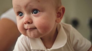 Mutlu bebek. Yatak odasındaki kanepede sürünen gülümseyen yeni doğmuş tatlı kız. Duygusal bebek gülümsemesi evdeki kanepede dinleniyor. Annelik mutlu çocuk bakımı konsepti