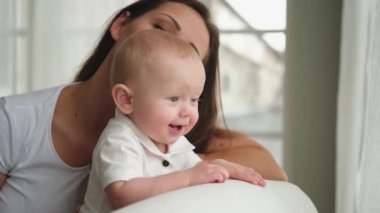 Evde mutlu bir aile. Anne ve küçük bir kız çocuğu. Anne ve yeni doğmuş bebek evde eğlenirken rahatlar. Anne bebeğe sevgiyle bakar. Bebeği emziren anne.