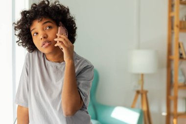 Evde akıllı telefondan konuşan Afrikalı Amerikalı bir kız. Cep telefonlu genç bir kadın arkadaşlarıyla sohbet ediyor. Gülümseyen genç kız cep telefonuyla cevap veriyor. Bayan cep telefonuyla konuşuyor.