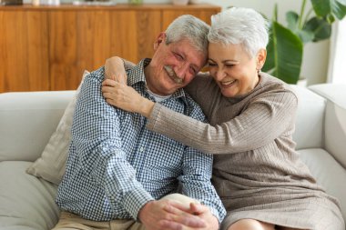 Yetişkin bir çiftin evde kucaklaşması. Orta yaşlı karı ve koca şefkatle kucaklaşıp tatlı bir bağ kurmanın tadını çıkarıyorlar. Büyükannem ve büyükbabam birlikte. Aile zamanı sevgi ve ilgi