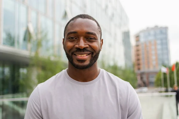 Happy african american man smiling outdoor. Portrait of young happy man on street in city. Cheerful joyful handsome person guy looking at camera. Freedom happiness carefree happy people concept