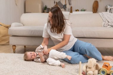 Evde mutlu bir aile. Anne ve bebek evde oyuncaklarla oynuyor. Küçük çocuk ve bebek bakıcısı birlikte eğleniyorlar. Genç kadın, anne, çocuk oturma odasında dinleniyor.