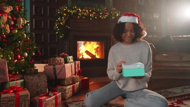 크리스마스 아프리카계 미국인 여성이 크리스마스 근처에 상자를 놓습니다 크리스마스 트리와 — 비디오