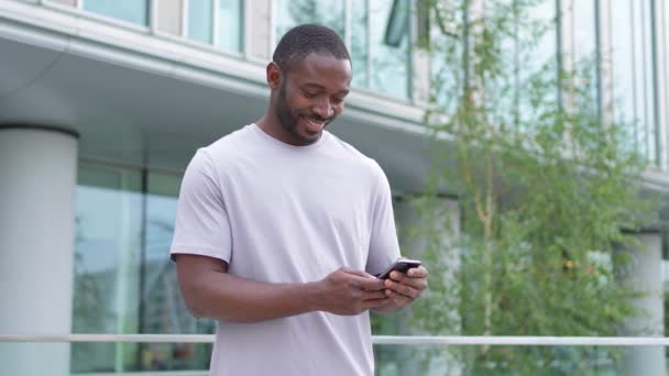 Afrikanischer Mann Mit Smartphone Touchscreen Eingabe Blätterseite Auf Der Städtischen — Stockvideo