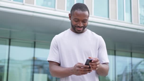Afroamerikansk Man Håller Smartphone Pekskärm Skriva Skriftrulle Sida Urban Gata — Stockvideo