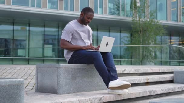 Hombre Afroamericano Freelancer Usando Laptop Escribiendo Chateando Calle Urbana Ciudad — Vídeo de stock