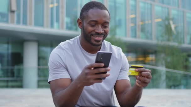 African American Man Shopping Online Innehav Smartphone Betala Med Guld — Stockvideo