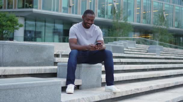 Glücklicher Afroamerikaner Euphorischer Sieger Mit Smartphone Auf Der Straße Der — Stockvideo