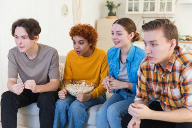 Bir grup arkadaş televizyonda futbol maçı izliyorlar. Memlekette zaferi kutlayan futbol taraftarları. Arkadaşlık sporu eğlence konsepti. Çeşitli arkadaşlar evde birlikte eğleniyorlar.