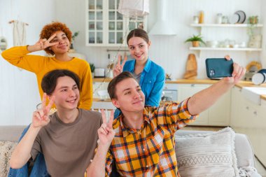 Keyfinize bakın. Mutlu arkadaş grubu selfie çekiyor. Partide arkadaşlarının fotoğrafını çeken bir adam. Telefonda fotoğraf çeken bir grup çok ırklı genç. Gençler gülümsemenin keyfini çıkarırlar.