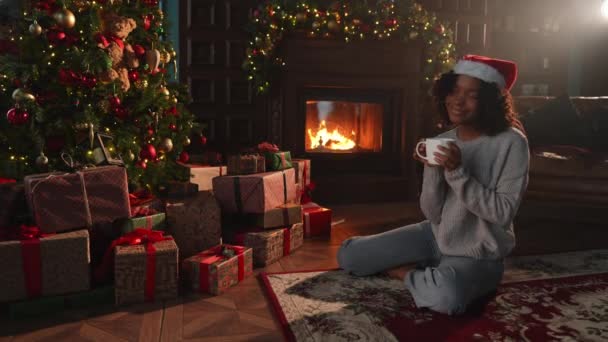 Wesołych Świąt Afroamerykanka Czapce Mikołaja Filiżanką Gorącej Kawy Przy Choince — Wideo stockowe