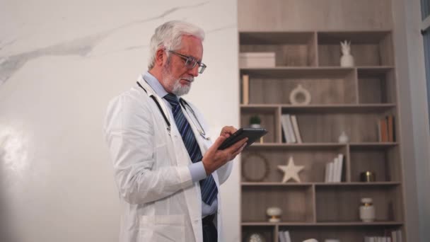 Médico Mayor Maduro Uniforme Médico Usando Tableta Digital Clínica Terapeuta — Vídeos de Stock