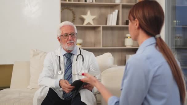 Senior Man Doctor Visita Giovane Donna Ambulatorio Medico Casa Paziente — Video Stock