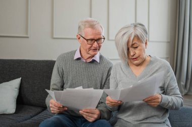 Orta yaşlı, üzgün, hayal kırıklığına uğramış yaşlı çift ellerinde kağıt belgelerle oturuyor. Mutsuz, olgun bir kadın kağıt tasarısı okuyor. Banka yönetiyor. Vergileri hesaplıyor.