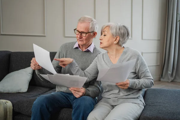 stock image Sad tired disappointed middle aged senior couple sit with paper document. Unhappy older mature man woman reading paper bill managing bank finances calculating taxes planning loan debt pension payment