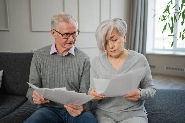 stock image Sad tired disappointed middle aged senior couple sit with paper document. Unhappy older mature man woman reading paper bill managing bank finances calculating taxes planning loan debt pension payment