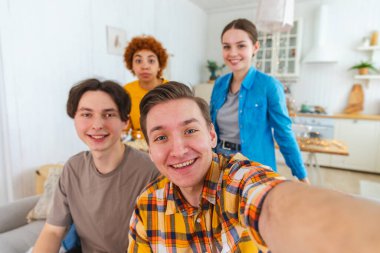 Keyfinize bakın. Mutlu arkadaşlar selfie çeker. Partide arkadaşlarının fotoğrafını çeken bir adam. Telefonda fotoğraf çeken bir grup çok ırklı insan. Gençler şirket tebessümlerinden hoşlanırlar. Web kamerası görünümü