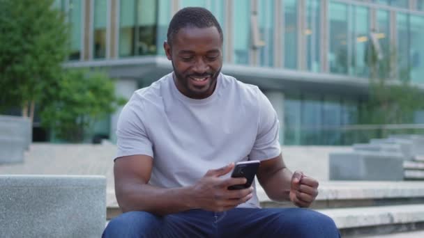 Щасливий Переможець Афроамериканської Людини Смартфоном Вулиці Місті Чоловік Який Дивиться — стокове відео