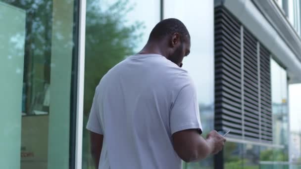Афроамериканец Сенсорным Экраном Смартфона Печатает Улице Городе Человек Сотовым Телефоном — стоковое видео