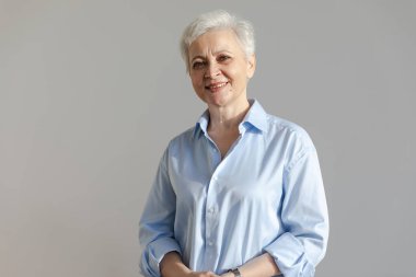 Kendine güveni tam, Avrupalı orta yaşlı, yaşlı bir kadın. 60 'lı yaşlarda beyaz arka planda gülümseyen olgun bir kadın. Mutlu, çekici, son sınıf öğrencisi, kamera görüntüsü, yüz portresi. Mutlu insanlar.