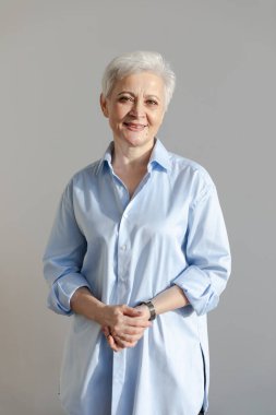 Kendine güveni tam, Avrupalı orta yaşlı, yaşlı bir kadın. 60 'lı yaşlarda beyaz arka planda gülümseyen olgun bir kadın. Mutlu, çekici, son sınıf öğrencisi, kamera görüntüsü, yüz portresi. Mutlu insanlar.