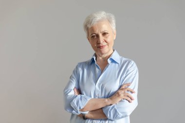 Kendine güveni tam, Avrupalı orta yaşlı, yaşlı bir kadın. 60 'lı yaşlarda beyaz arka planda gülümseyen olgun bir kadın. Mutlu, çekici, son sınıf öğrencisi, kamera görüntüsü, yüz portresi. Mutlu insanlar.