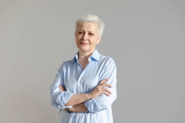 Kendine güveni tam, Avrupalı orta yaşlı, yaşlı bir kadın. 60 'lı yaşlarda beyaz arka planda gülümseyen olgun bir kadın. Mutlu, çekici, son sınıf öğrencisi, kamera görüntüsü, yüz portresi. Mutlu insanlar.