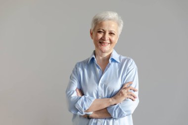 Kendine güveni tam, Avrupalı orta yaşlı, yaşlı bir kadın. 60 'lı yaşlarda beyaz arka planda gülümseyen olgun bir kadın. Mutlu, çekici, son sınıf öğrencisi, kamera görüntüsü, yüz portresi. Mutlu insanlar.