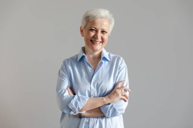 Kendine güveni tam, Avrupalı orta yaşlı, yaşlı bir kadın. 60 'lı yaşlarda beyaz arka planda gülümseyen olgun bir kadın. Mutlu, çekici, son sınıf öğrencisi, kamera görüntüsü, yüz portresi. Mutlu insanlar.