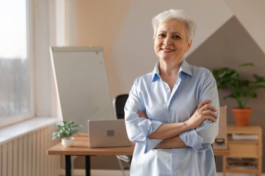 İş yerinde kendine güveni tam orta yaşlı Avrupalı bir kadının portresi. Modern ofisteki yaşlı, şık, 60 'lı yaşlarda, beyaz saçlı, bayan iş kadını. Patron öğretmen profesyonel işçi.