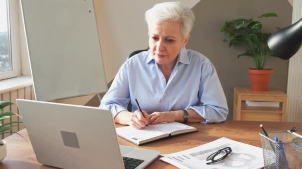 Starsza Kobieta Średnim Wieku Używająca Laptopa Pisania Notatek Miejscu Pracy — Wideo stockowe