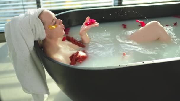 Spa Rahatlaması Kırmızı Gül Yapraklarıyla Banyoda Yatan Bir Kadın Kız — Stok video