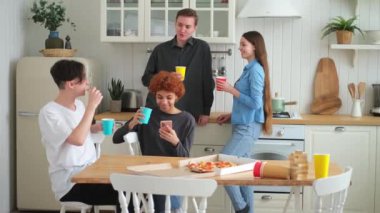 Ev partisi. Arkadaşlar birlikte vakit geçirip gülerek ve evde iletişim kurarak eğleniyorlar. Bira ya da limonata içerek pizza yiyen mutlu bir grup. Karışık yarış genç dostları, en iyi arkadaşlar hafta sonunun tadını çıkarın.