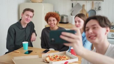 Keyfinize bakın. Mutlu arkadaş grubu selfie çekiyor. Partide arkadaşlarının fotoğrafını çeken bir adam. Telefonda fotoğraf çeken bir grup çok ırklı genç. Gençler gülümsemenin keyfini çıkarırlar.