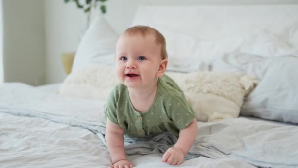 快乐的宝贝 可爱的新生小女孩 笑脸爬在床上睡在卧室里 婴儿在家里躺在毛毯上玩耍 母亲快乐儿童保育概念 — 图库视频影像