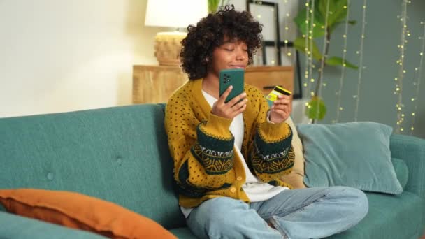 African American Woman Shopping Online Holding Smartphone Paying Gold Credit — Stok video