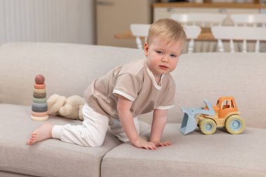 Mutlu bebek. Küçük şirin çocuk içeride koltukta oyuncaklarla oynuyor. Çocuk evde eğleniyor. Bebek evdeki oturma odasında dinleniyor. Annelik eğitimi oyun konseptiyle öğreniliyor