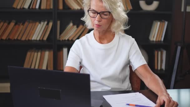Starsza Kobieta Średnim Wieku Używająca Laptopa Pisania Notatek Miejscu Pracy — Wideo stockowe