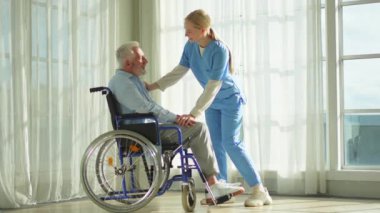 Emeklilik sağlık hizmetlerine destek ol. Hemşire tekerlekli sandalyedeki yaşlı adama yardım ediyor. Hasta ve kadın tıbbi bakım için huzurevinde. Engelli insanlar için tekerlekli sandalyede felçli bir adama bakan hemşire.