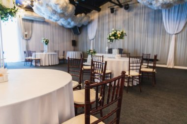 Şenlik için dekore edilmiş iç mekan. Restoranda çiçek kompozisyonu olan lüks bir masa, iç mekan. Yemek servisinin düzenlediği zarif düğün ziyafeti dekorasyonu.