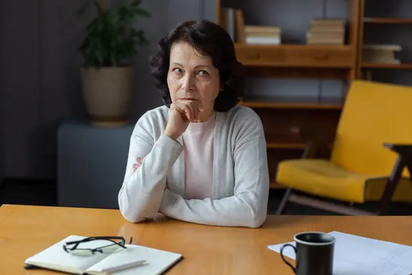 stock image Sad tired ill sick lonely disappointed older senior woman sitting at home alone. Unhappy mature grandmother experiencing grief relative death bad news. Stressed elder lady suffering from loneliness