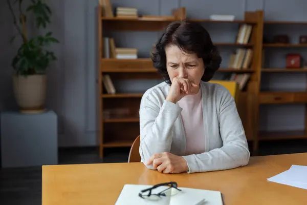 stock image Sad tired ill sick lonely disappointed older senior woman sitting at home alone. Unhappy mature grandmother experiencing grief relative death bad news. Stressed elder lady suffering from loneliness