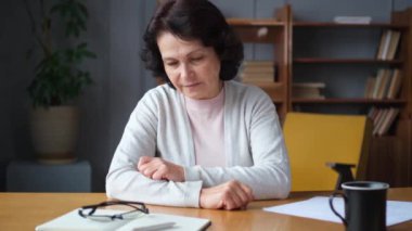 Üzgün, hasta, yalnız, yaşlı bir kadın evde yalnız oturuyor. Mutsuz, olgun bir büyükanne yas tutuyor. Ölümüne kötü haber. Stresli yaşlı kadın yalnızlıktan muzdarip.