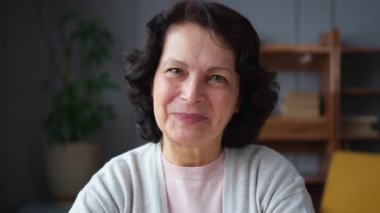 Kendine güveni tam orta yaşlı Avrupalı bir kadının portresi. Evde gülümseyen 60 'lı yaşlarda olgun bir kadın. Mutlu, çekici, son sınıf öğrencisi, kamera görüntüsü, yüz portresi. Mutlu insanlar.